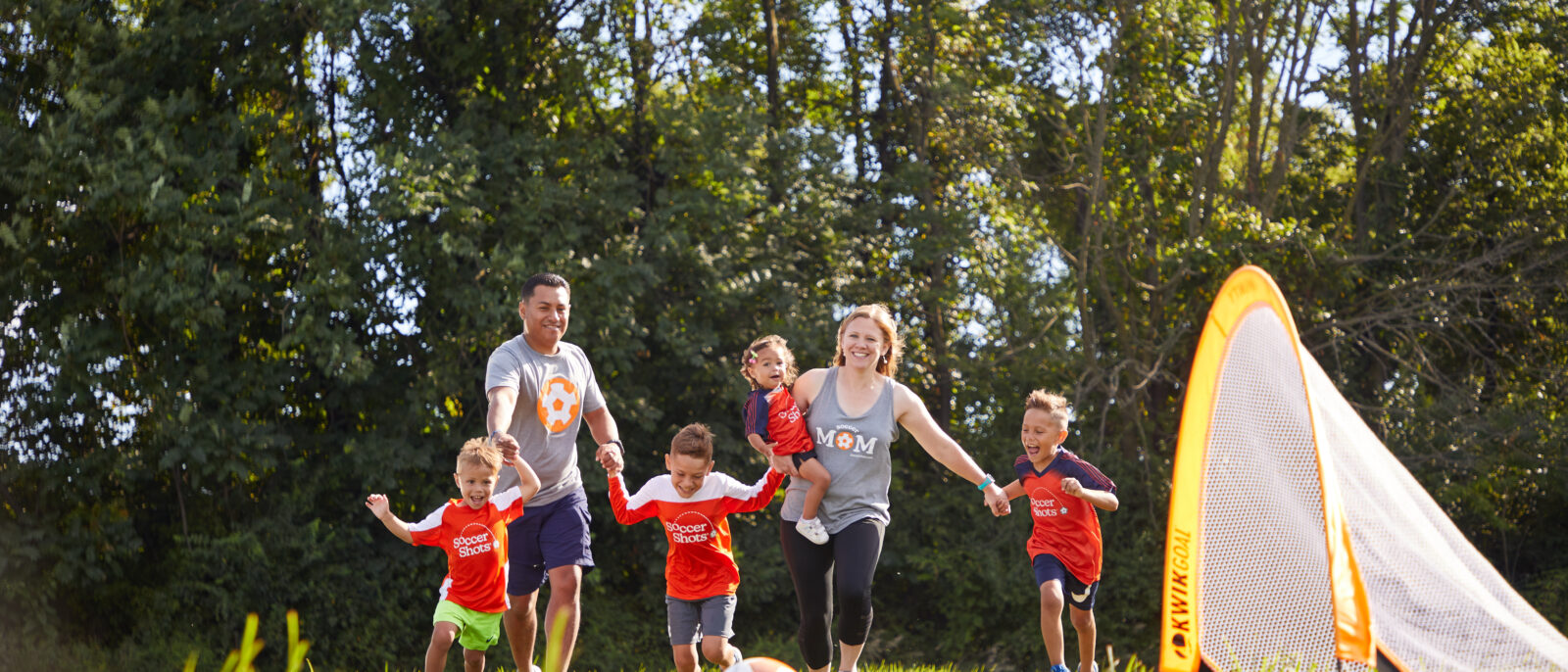 Family running on soccer pitch