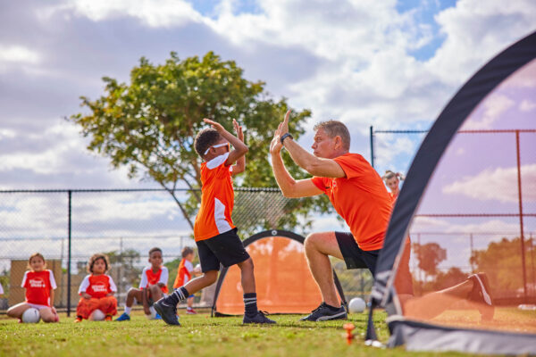 Child and coach high fiving